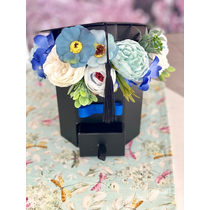 Fekete ballagós kalapos papírdoboz díszítve minőségi selyemvirágokkal, zöldekkel. A doboz alján beépített fiókkal, ahova elhelyezhető a kisebb ajándék vagy a pénz-ballagási ajándék-álom kertem