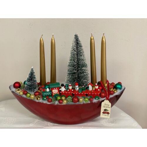 Piros csónaktál díszítve arany gyertyákkal, fenyőfákkal, piros-zöld vonattal, piros, zöld arany bogyókkal, termésekkel, üveggömbökkel-karácsonyi dekoráció-álom ker